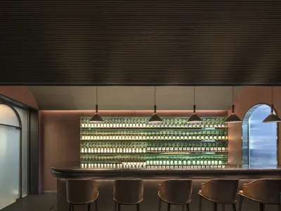Modern bar interior featuring metallic shelves and light fixtures.