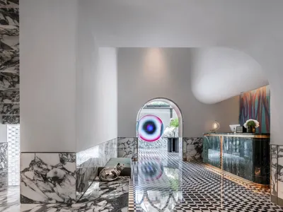 Interior view of a modern hotel lobby featuring marble flooring and a reception desk.