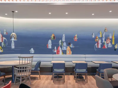 A modern restaurant interior featuring a colorful fish wall art mural.
