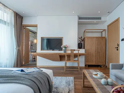 A modern bedroom featuring wood furniture and textiles, designed for comfort and style.