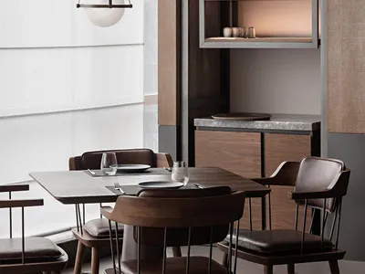 A modern restaurant interior featuring wooden furniture, metal accents, and glass elements.
