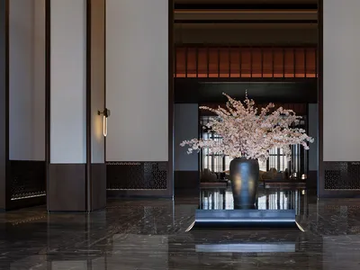 Modern hotel lobby with a marble floor and black vase with pink flowers.
