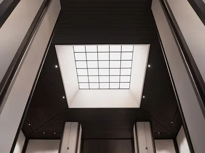 A sleek, modern hotel lobby featuring metallic columns and a skylight.