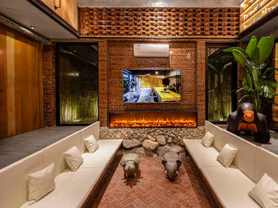 A cozy industrial-style living room with brick walls, a fireplace, and comfortable seating.