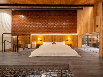 A minimalist bedroom with a bed, nightstands, and lights.