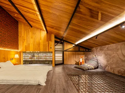 現代臥室擁有木質牆面、地板與天花板，設有床鋪及舒適的休憩區，配有枕頭與狐狸擺飾
