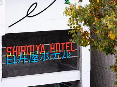 現代飯店入口，展示金屬框架招牌搭配霓虹燈光