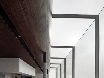 Modern minimalist restaurant interior with large glass windows and marble flooring.