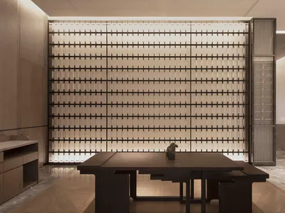 Modern hotel lobby featuring glass wall panels and minimalist furniture.