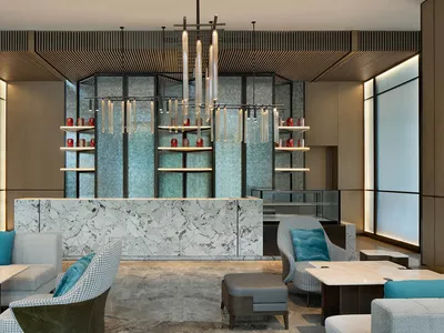 A modern hotel lobby featuring marble and glass elements