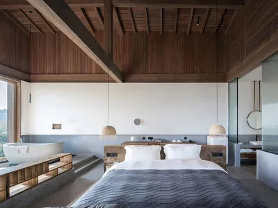 Spacious bedroom with minimalist design, featuring a large bed, wooden floor, and large windows.