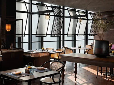 A modern restaurant interior with wooden furnishings and decorative elements.