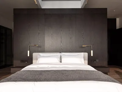 A minimalist bedroom with a double bed, dark wooden headboard, and skylight allowing natural light in.