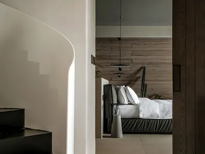 A modern bedroom with brown wooden walls and a minimalist bed setup.