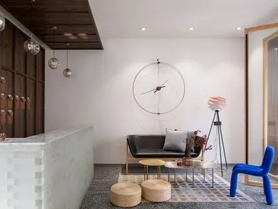 Modern hotel lobby with concrete flooring, minimalistic furniture, and sleek design features.
