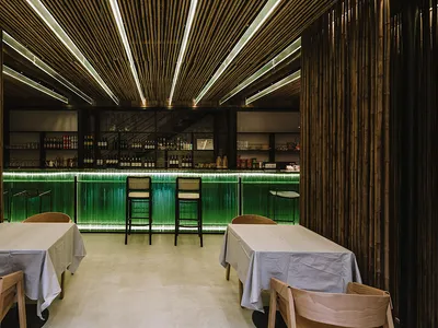 Bamboo-themed restaurant bar interior with modern lighting and seating.
