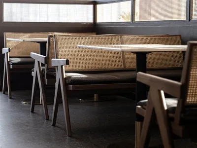 Industrial-style seating with cane backs and metal frames in a restaurant setting.