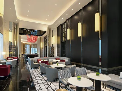 A modern hotel lobby with a sleek design featuring black and white geometric flooring, contemporary seating, and hanging lamp