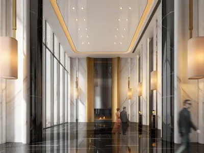 A modern hotel lobby with marble walls, glass columns, and a central fireplace.
