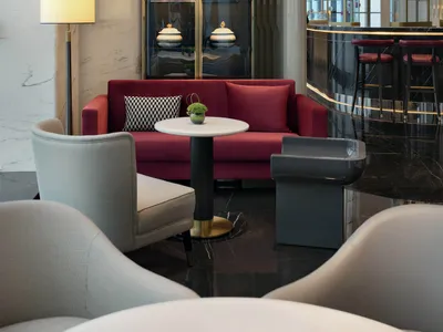 Modern hotel lounge with marble furniture and contemporary design elements.
