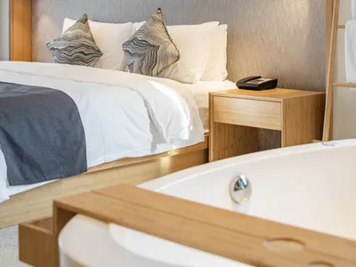 A modern minimalist bedroom featuring minimalist furniture and wood accents.