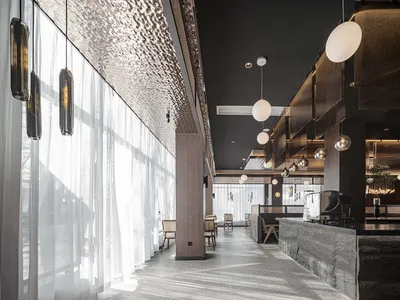 Modern restaurant interior featuring glass, metal, and wood materials.