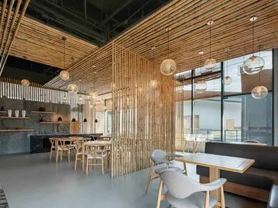 A modern restaurant interior featuring wood elements and hanging lights.