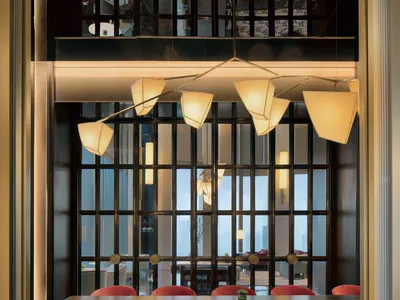 A modern restaurant interior featuring mixed materials, with a focus on the dining area and unique lighting fixtures.