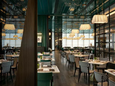 Modern restaurant interior with elegant design elements, featuring table settings and contemporary furnishings.
