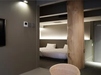 A modern bedroom featuring concrete walls and wooden accents.