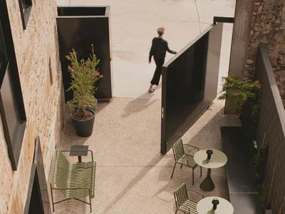 A modern restaurant with concrete exterior and pottery planters.