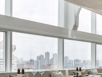 Modern restaurant interior featuring wooden seating and cushioned accents.