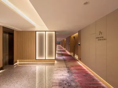 現代飯店走廊，木質地板與發光牆面。