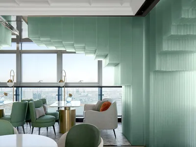 Modern restaurant interior with green acrylic and glass materials and a view of the cityscape from the large windows.