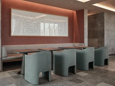 Seating area in an industrial-themed restaurant with concrete walls, chairs, and tables.