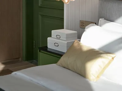 A minimalist bedroom featuring a modern light fixture and textured bedding.