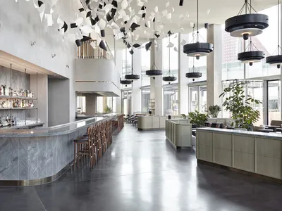 A modern restaurant interior featuring concrete, glass, and marble materials.