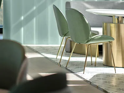 Modern restaurant seating area with metallic bronze tables and chairs, featuring a contemporary design with minimalistic seat