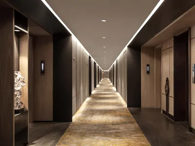 Modern, elegant hotel corridor lined with wooden tiles and featuring a long, empty hallway.