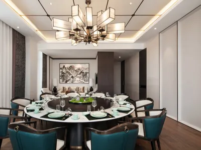 Modern dining room with round table, chairs, and chandelier.