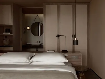 Modern minimalist bedroom with white bedding, wooden furniture, and a round mirror.