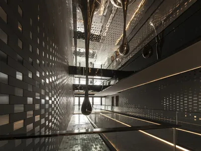 Modern hotel corridor featuring metallic tiles and steel elements.