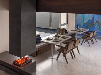 Industrial-style restaurant interior with concrete floor, wooden tables, and metal chairs.