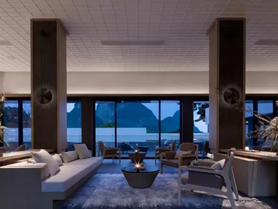 Modern lounge area with glass walls, comfortable seating, and a cozy atmosphere.