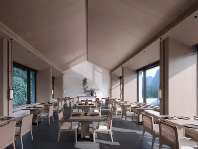 Modern restaurant interior with concrete finishes, white chairs, and large windows.
