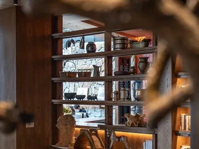 Industrial-style restaurant interior featuring wooden tables, leather chairs, and upholstered seating.