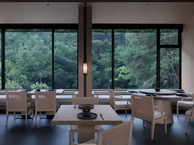 A restaurant interior featuring white wood furnishings, animal skin accents, and a marble counter.