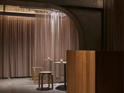 Industrial-style restaurant interior with fabric curtains.