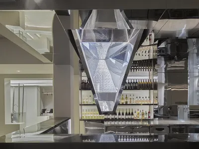 A modern bar with glass walls and reflections in a hospitality interior setting.