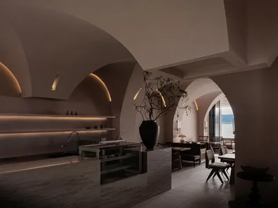 Interior design of a modern restaurant lobby with concrete walls and ambient lighting.